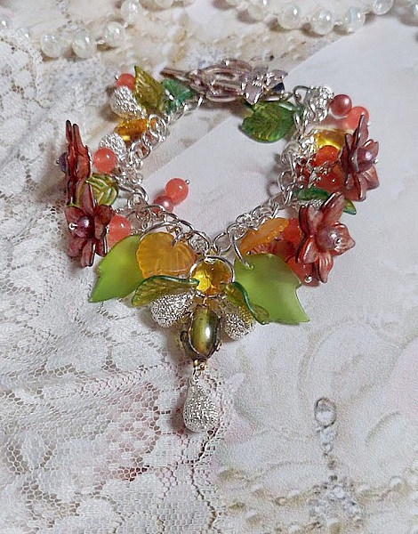 Bracelet gourmette argenté avec fleurs, feuilles et jade orange.