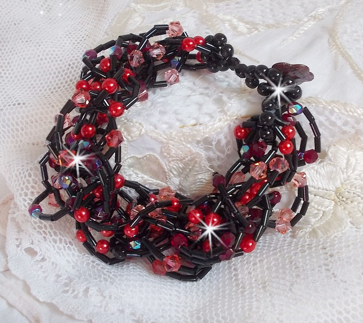 Feeling-armband med rörpärlor, pärlemorspärlor och snurrande toppar i Swarovski-kristall.