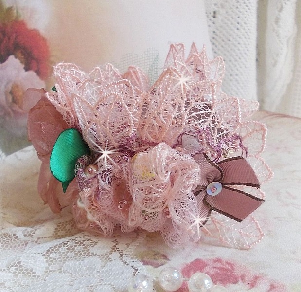 Douceur Poudr&eacute;e-armband med fin rosa spets, Swarovski-kristaller, glasp&auml;rlor, fr&ouml;p&auml;rlor och guldpl&auml;terade tillbeh&ouml;r.