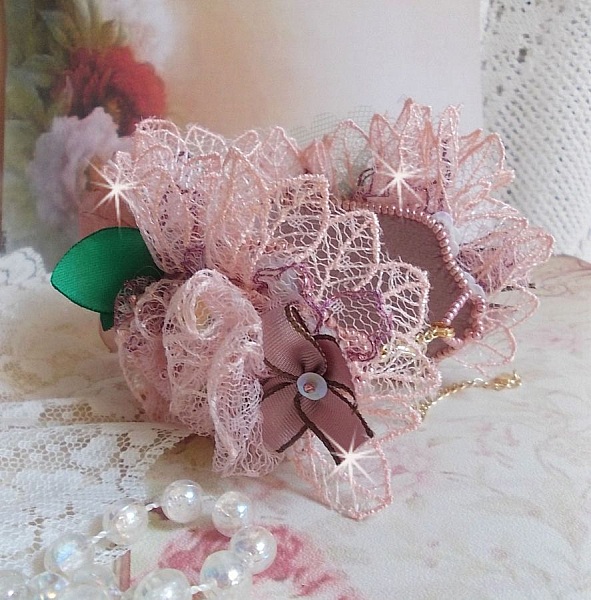 Douceur Poudr&eacute;e-armband med fin rosa spets, Swarovski-kristaller, glasp&auml;rlor, fr&ouml;p&auml;rlor och guldpl&auml;terade tillbeh&ouml;r.