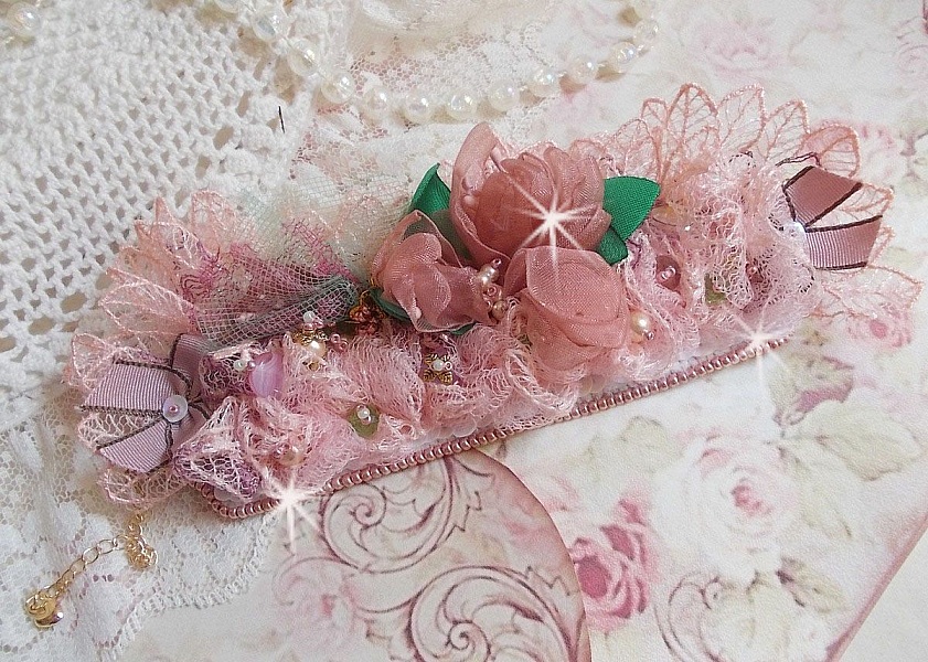 Douceur Poudr&eacute;e-armband med fin rosa spets, Swarovski-kristaller, glasp&auml;rlor, fr&ouml;p&auml;rlor och guldpl&auml;terade tillbeh&ouml;r.