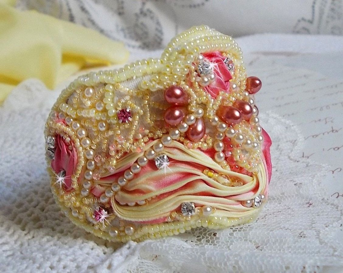 Les Délices de L'Eté manschettarmband Haute-Couture broderat med ett gult och rosa sidenband, runda pärlor, pärldroppar och pärlpärlor.