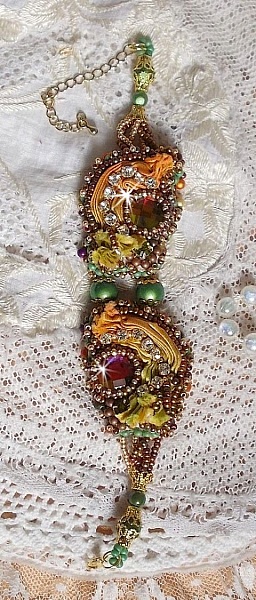 Bracelet artisanal brodé en soie et perles aux tons chauds.
