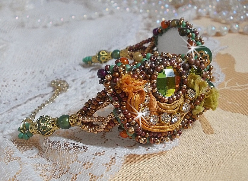 Bracelet artisanal brodé en soie et cristaux aux couleurs chaudes.