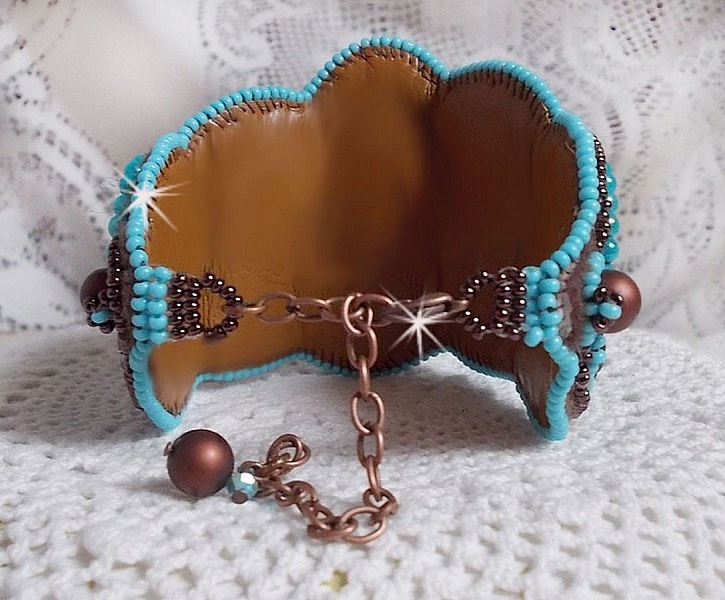 Bracelet manchette artisanal en cuir avec perles turquoise brodées.
