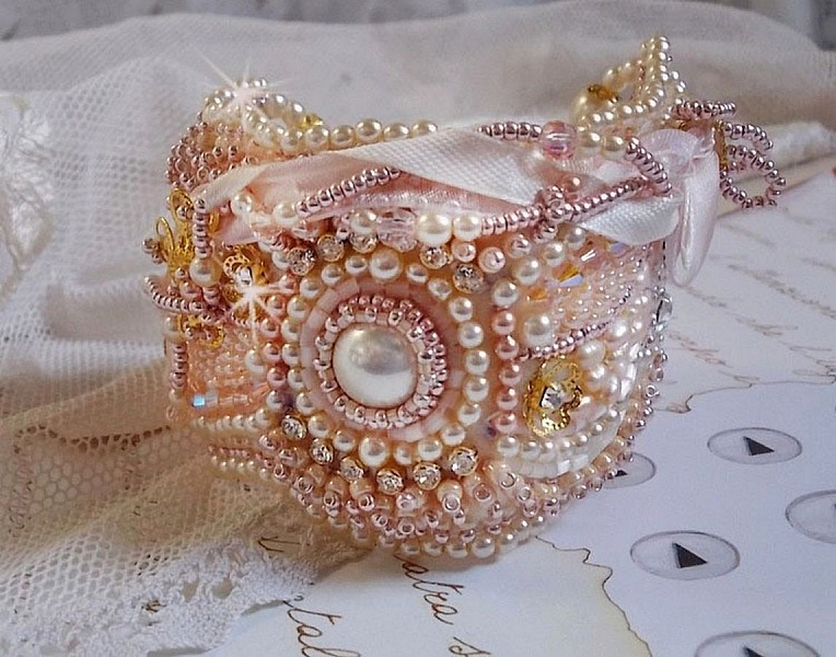 Rice powder manschettarmband broderat med s&ouml;tvattenskulturp&auml;rlor, p&auml;rlor, fr&ouml;p&auml;rlor och Swarovski-kristaller.