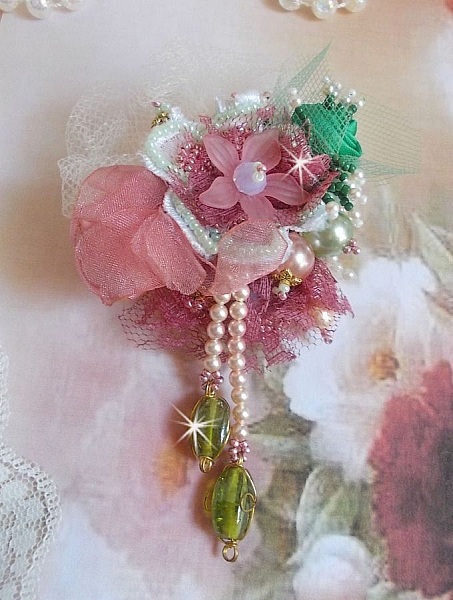 Soft Powdered brosch skapad med spets, organza band, Swarovski p&auml;rlor, glasp&auml;rlor och fr&ouml;p&auml;rlor. 