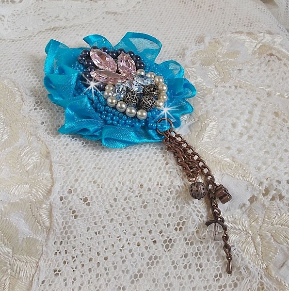 Belle Epoque Haute-Couture brosch &auml;r broderad med Swarovski-kristaller, runda p&auml;rlor, berlocker, band och fr&ouml;p&auml;rlor.