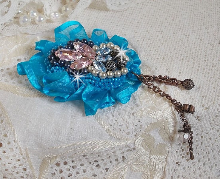 Belle Epoque Haute-Couture brosch &auml;r broderad med Swarovski-kristaller, runda p&auml;rlor, berlocker, band och fr&ouml;p&auml;rlor.
