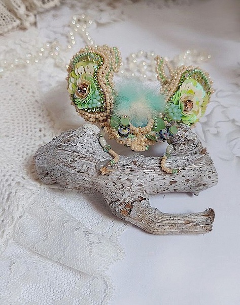 Broche artisanale en forme d'insecte brodée de perles et sequins.