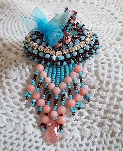 Naiadbrosch broderad med &auml;delstensp&auml;rlor (turkos och korall), kristaller, kohud och fr&ouml;p&auml;rlor.