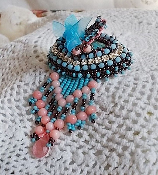 Naiadbrosch broderad med &auml;delstensp&auml;rlor (turkos och korall), kristaller, kohud och fr&ouml;p&auml;rlor.