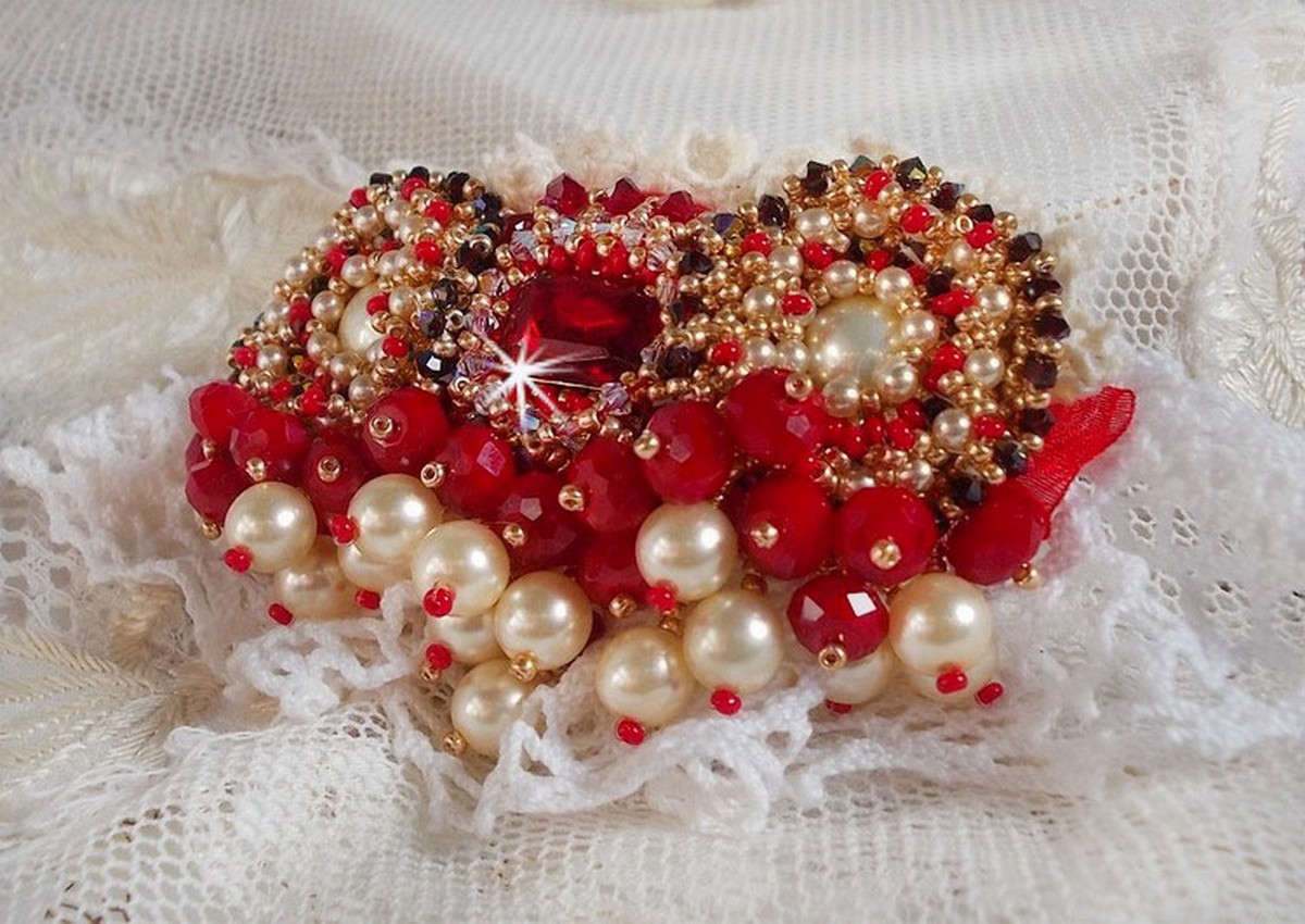 Rubinbrosch broderad med en bohemisk glascabochon från 1960-talet, pärlor, Swarovskikristaller och fröpärlor.