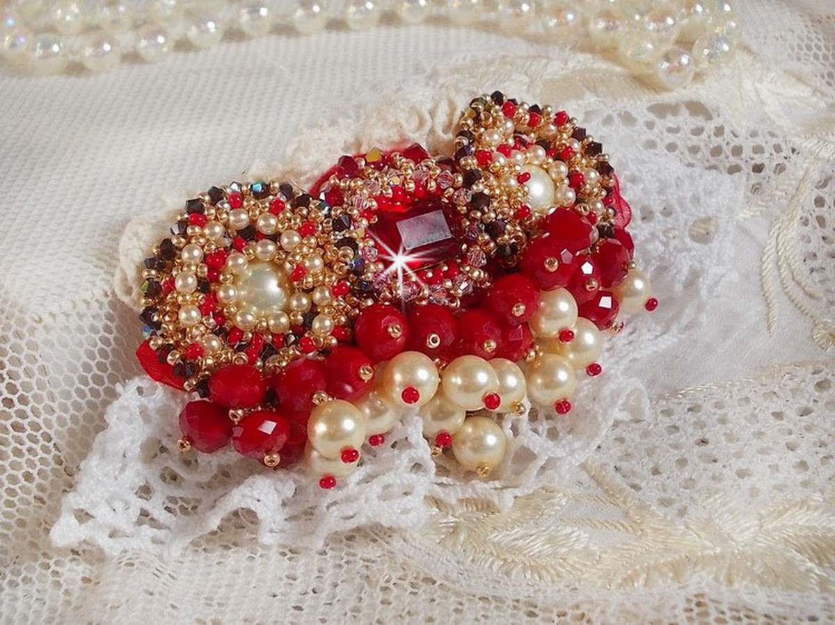 Rubinbrosch broderad med en bohemisk glascabochon från 1960-talet, pärlor, Swarovskikristaller och fröpärlor.