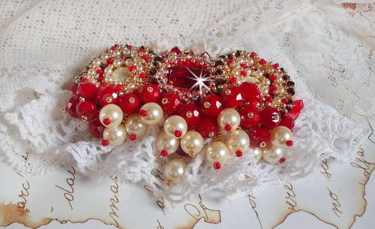 Rubinbrosch broderad med en bohemisk glascabochon från 1960-talet, pärlor, Swarovskikristaller och fröpärlor.