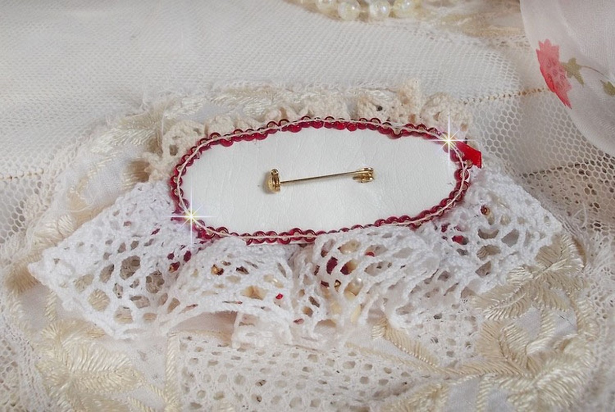 Rubinbrosch broderad med en bohemisk glascabochon från 1960-talet, pärlor, Swarovskikristaller och fröpärlor.