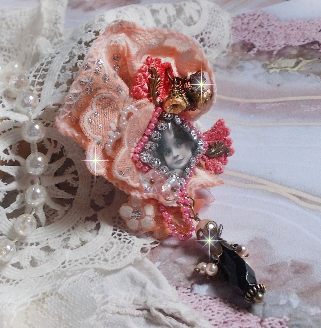 Rustik Rose brosch skapad med en cabochon som föreställer en leende flicka, orange strass och Rose spets, kristaller, glaspärlor och olika tillbehör.