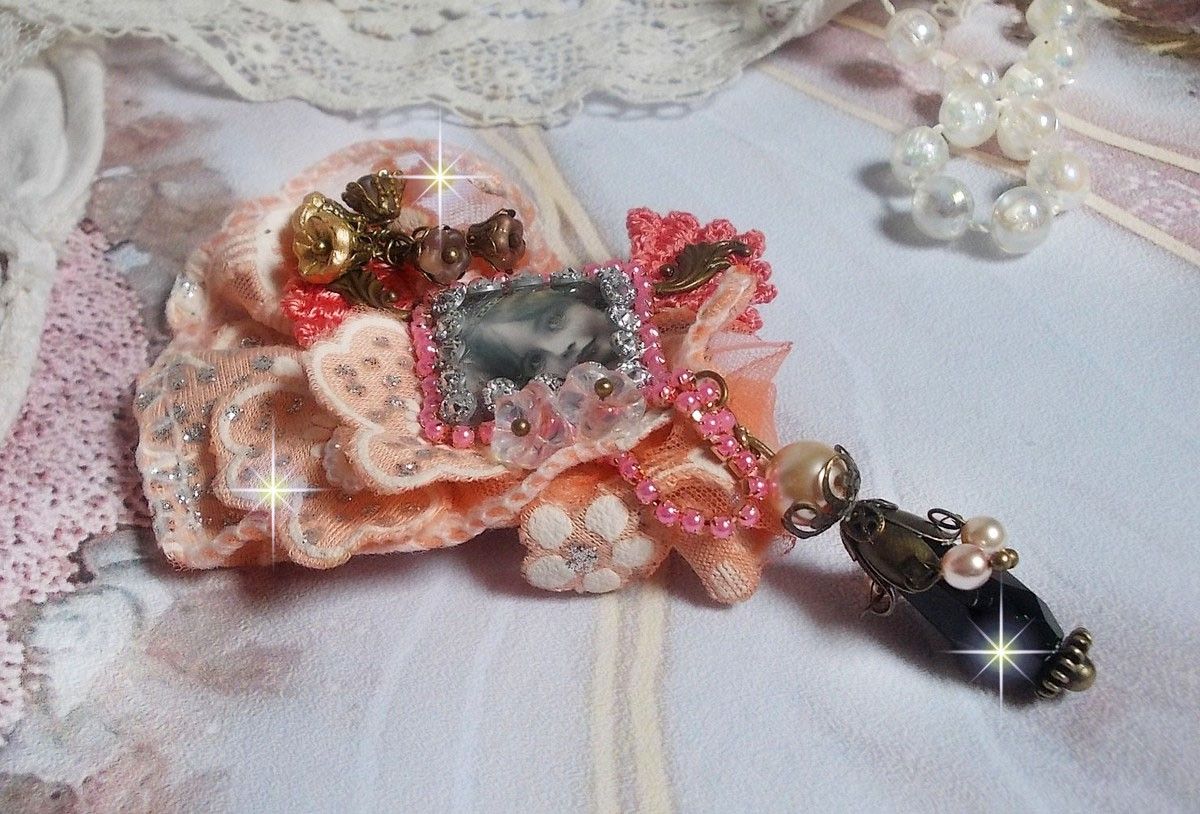 Rustik Rose brosch skapad med en cabochon som föreställer en leende flicka, orange strass och Rose spets, kristaller, glaspärlor och olika tillbehör.