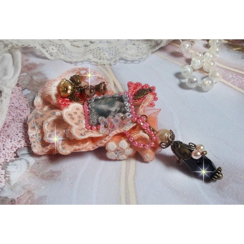 Rustik Rose brosch skapad med en cabochon som föreställer en leende flicka, orange strass och Rose spets, kristaller, glaspärlor och olika tillbehör.