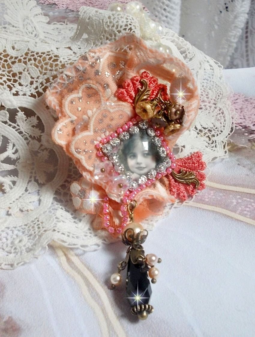 Rustik Rose brosch skapad med en cabochon som föreställer en leende flicka, orange strass och Rose spets, kristaller, glaspärlor och olika tillbehör.