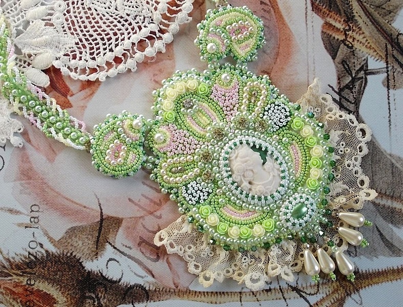 Anisse Haute-Couture halsband med br&ouml;stpl&aring;t, broderat med antik spets, cabochon i harts med ett kvinnoportr&auml;tt.