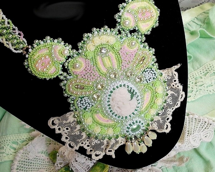 Anisse Haute-Couture halsband med br&ouml;stpl&aring;t, broderat med antik spets, cabochon i harts med ett kvinnoportr&auml;tt.
