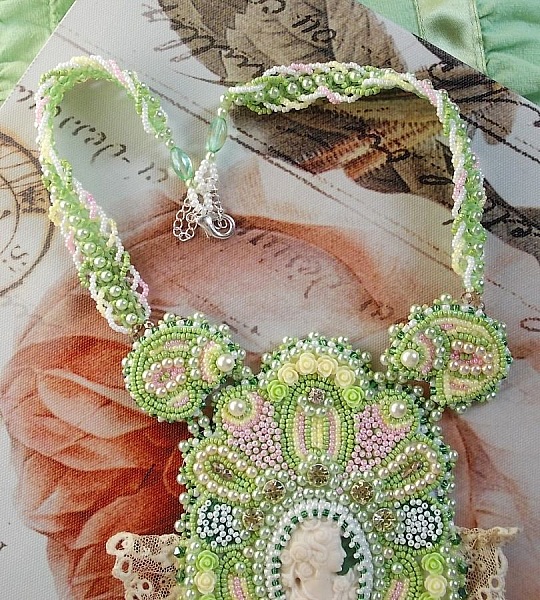 Anisse Haute-Couture halsband med br&ouml;stpl&aring;t, broderat med antik spets, cabochon i harts med ett kvinnoportr&auml;tt.