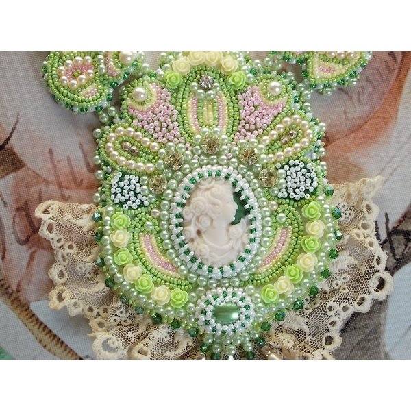 Anisse Haute-Couture halsband med br&ouml;stpl&aring;t, broderat med antik spets, cabochon i harts med ett kvinnoportr&auml;tt.