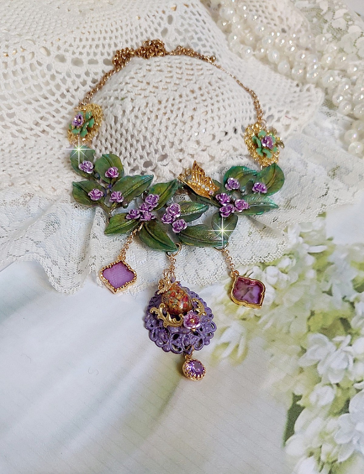 Collier Cam&eacute;lia Japonica mont&eacute; avec un motif feuilles aquarell&eacute;s &agrave; la main, paillettes, breloques papillons et abeille, roses m&eacute;tal, cabochon cristal, pendentifs &eacute;poxy aux couleurs d&rsquo;arc en ciel