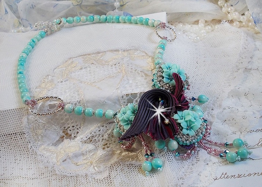 Blue Flowers Haute-Couture halsband broderat med Swarovski-kristaller, ett tryffel/hallon-silkesband och fr&ouml;p&auml;rlor.