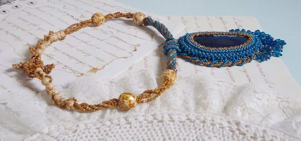 Korsika hängande halsband broderat med safirblå agat och beigefärgade fröpärlor