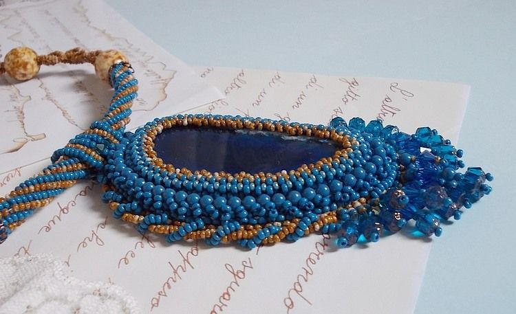Korsika hängande halsband broderat med safirblå agat och beigefärgade fröpärlor