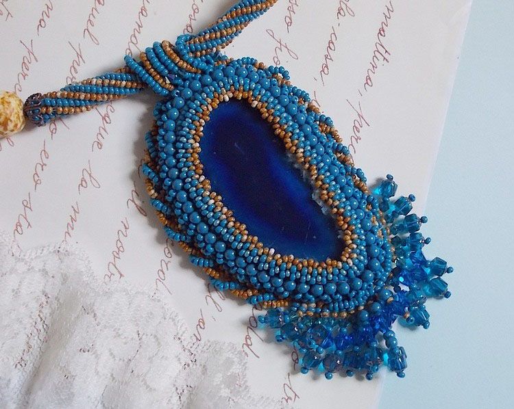 Korsika hängande halsband broderat med safirblå agat och beigefärgade fröpärlor