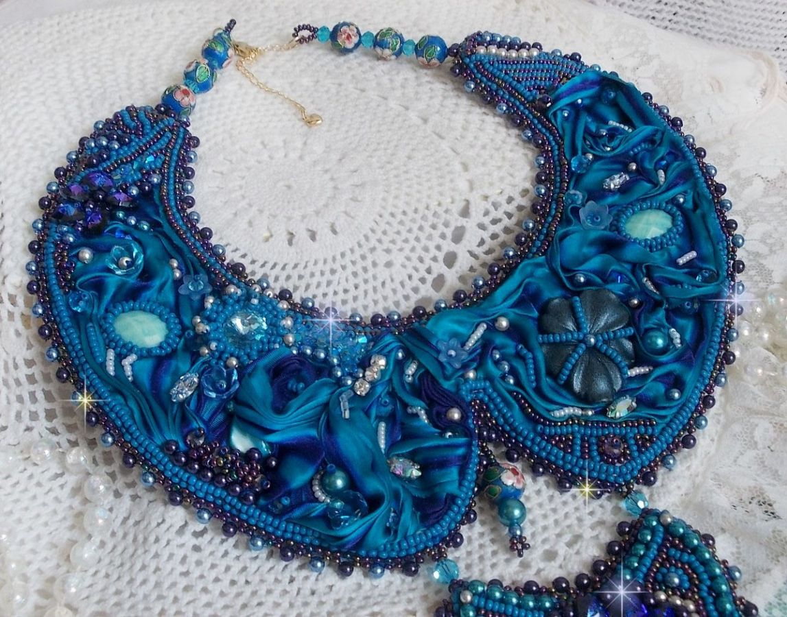 Kungligt blått Haute-Couture halsband broderat med ett lila och ankblått sidenband, kristaller och olika pärlor. 