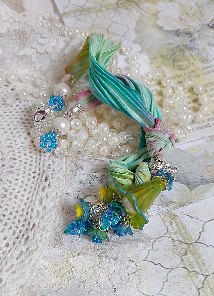 Collier artisanal avec ruban de soie et fleurs acryliques colorées.