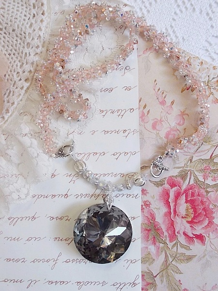 Coco h&auml;ngande halsband broderat med Swarovskikristaller och en medaljong i r&ouml;kt kristall