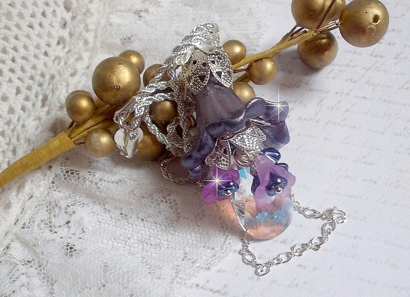 Pendentif Eclat de Cristal mont&eacute; avec une goutte en Cristal, fleurs en Verre, fleurs lucites dont une plus grande peinte &agrave; la main avec paillettes Argent&eacute;es. Une composition florale