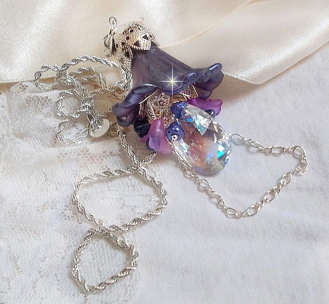 Pendentif Eclat de Cristal mont&eacute; avec une goutte en Cristal, fleurs en Verre, fleurs lucites dont une plus grande peinte &agrave; la main avec paillettes Argent&eacute;es. Une composition florale