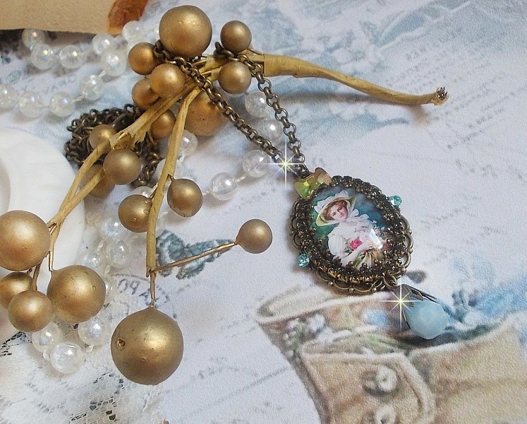 Pendentif Douce Dame cr&eacute;&eacute; avec un cabochon repr&eacute;sentant une femme au chapeau blanc orn&eacute; de cristaux, des accessoires de couleur Bronze et un jade teint&eacute; bleu 