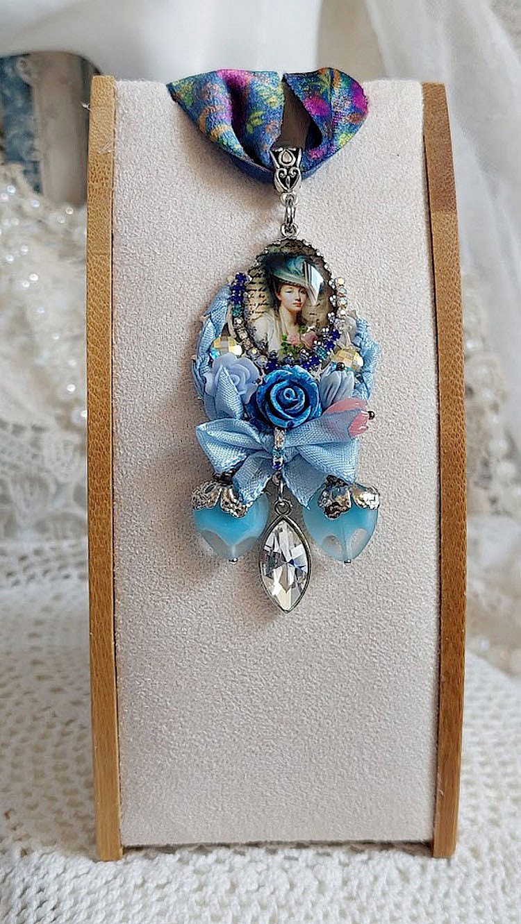 Pendentif Infiniment Bleut&eacute; cr&eacute;&eacute; avec fleurs synth&eacute;tiques, r&eacute;sine, cabochon verre, ruban velours et perles Cristal Swarovski