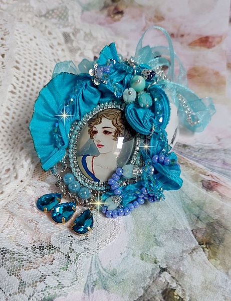 Pendentif Mademoiselle au style r&eacute;tro avec cabochon d&rsquo;une femme souriante, orn&eacute; d&rsquo;un ruban de soie Bleu, cristaux, perles verre : rocailles et roses, coupelles et cha&icirc;ne Argent 925/1000