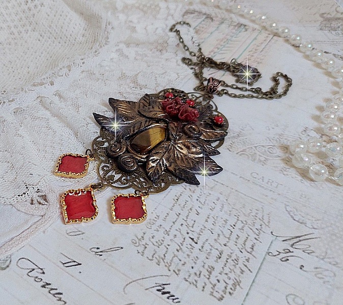 Pendentif M&eacute;lodie avec un cabochon &OElig;il de tigre orn&eacute; de perles en Jade Rouge vein&eacute; de Noir sur fleurs 5 p&eacute;tales et estampes mont&eacute;s sur une cha&icirc;ne bronze. Les pendants sont en r&eacute;sine &eacute;poxy Rouge