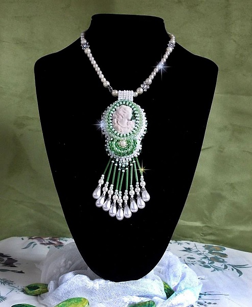 Seduction Charm h&auml;nge broderat med en harts cabochon av en kvinna med rosor, Swarovski kristaller och olika p&auml;rlor