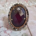 Chic burgundy ring skapad med PureCrystal kristaller, en blommaformad stämpel och en glascabochon.