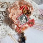 Rustik Rose brosch skapad med en cabochon som föreställer en leende flicka, orange strass och Rose spets, kristaller, glaspärlor och olika tillbehör.