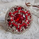Drigon Red ring broderad med en röd Swarovski-kristallcabochon, silverbälten och fröpärlor.