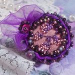Romantisk Lady Ring broderad på ett rosa linnetyg med rosa, iris, lila och persika pärlor. 