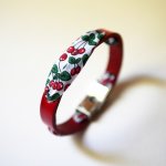 Florâme-armband med band av körsbärsfrukt på rött läder