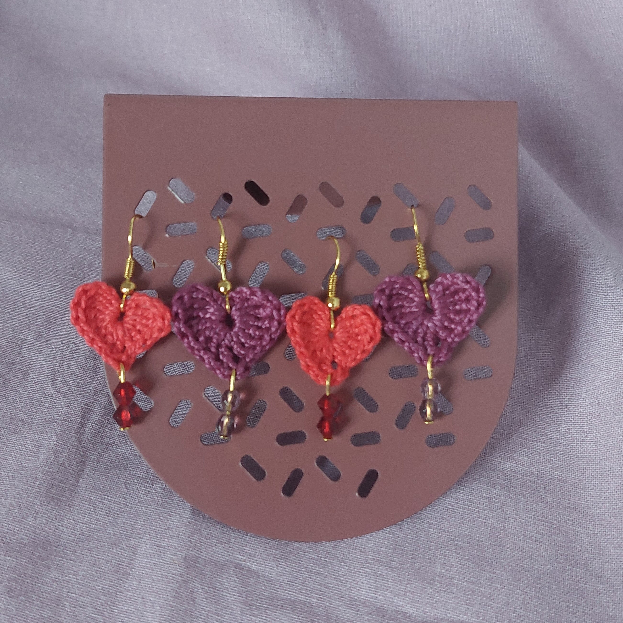 Boucles d'oreilles cœurs en crochet avec perles colorées.