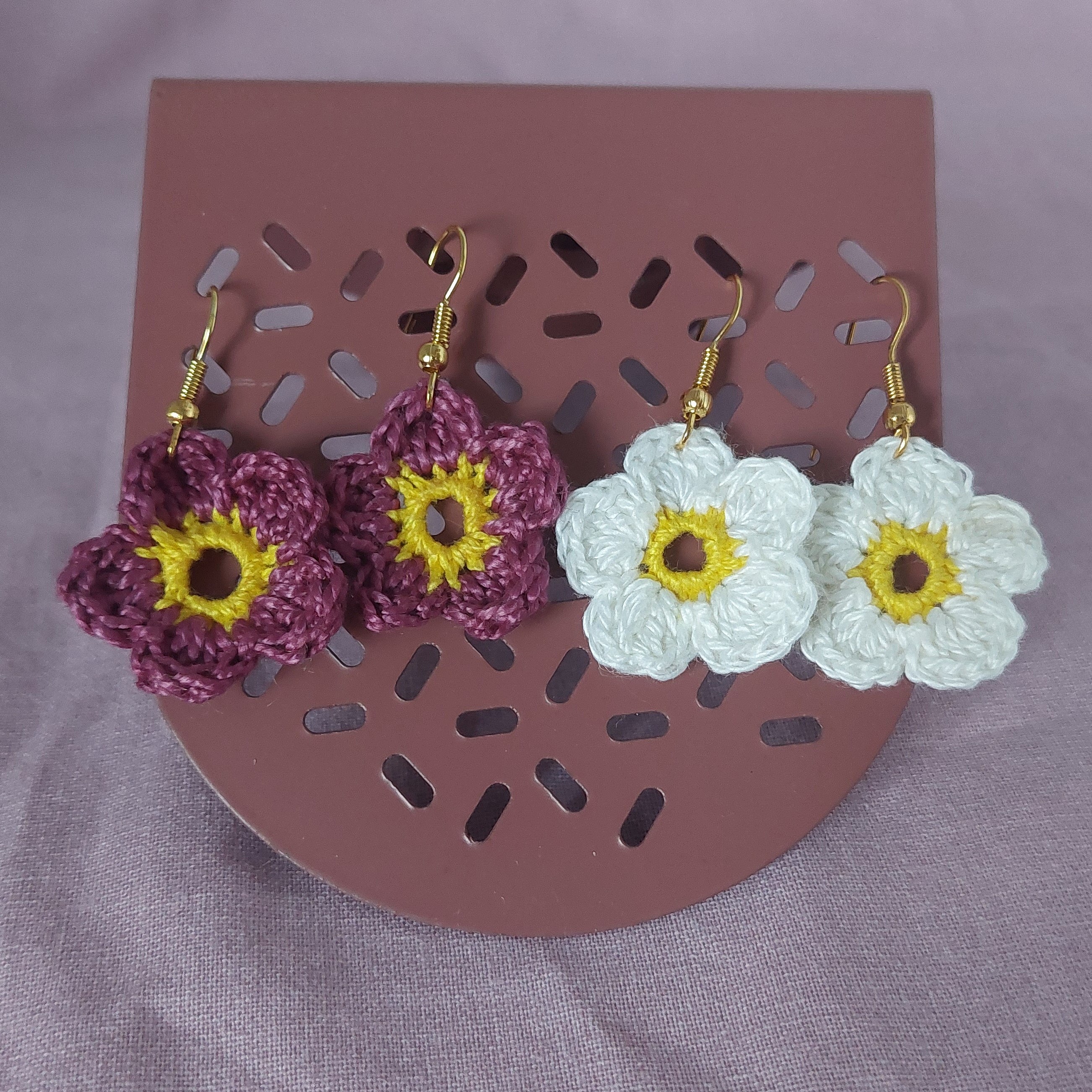 Boucles d'oreilles en forme de fleurs réalisées au crochet.